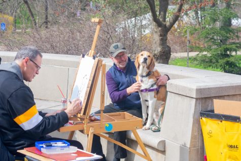 President Finegold and his dog, Louis, pose for a caricature at the Spring Carnival on April 2.
