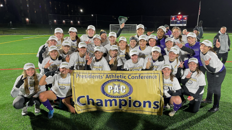 Head coach Betsy Warren alongside her team after winning the Presidents Athletic Conference