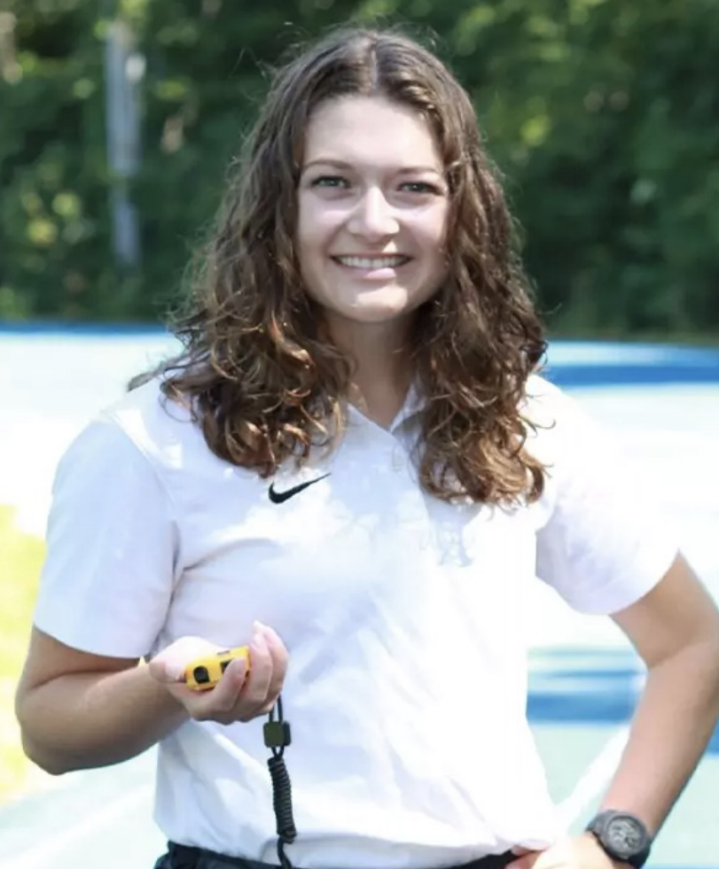 Rebecca Pennington ‘22 holds a stopwatch while coaching at Berea College. Photo provided by Chatham Athletics.