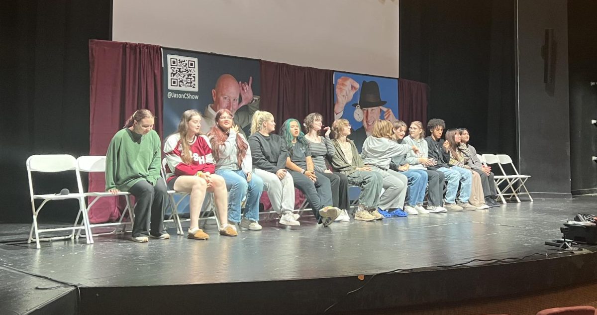 Participants sit on the Eddy Theatre stage to be hypnotized. Photo credit: Joey DeLucia