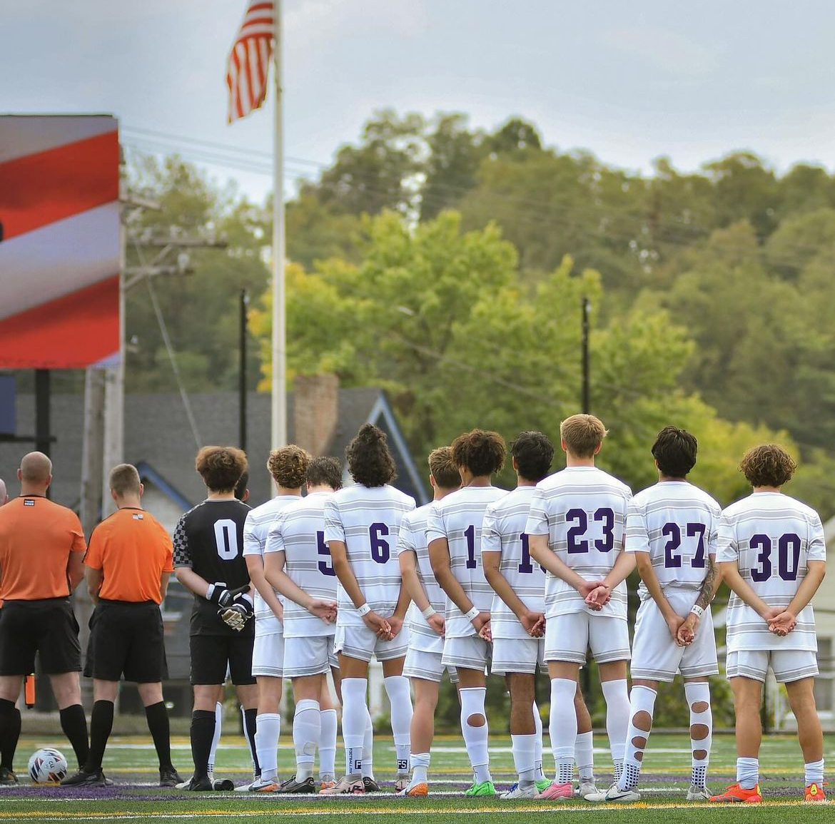 The men's soccer team stands for pregmae national anthem. Photo Credit: Amber Fendley