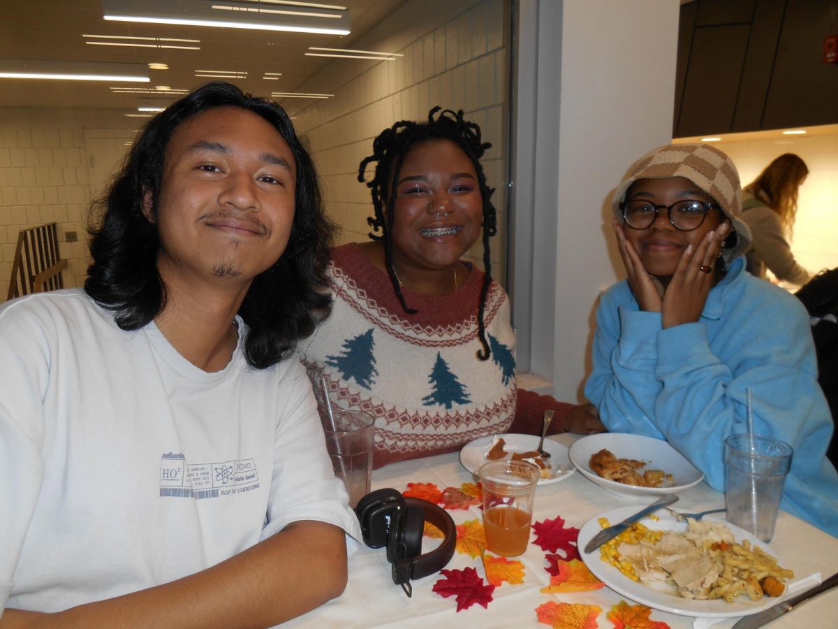 Andrei Arboleda '27, Keyonna White '27 and Countess Lingard '27 enjoy food at Anderson Dining Hall's Harvest Dinner.