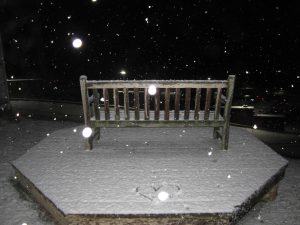 Bench outside of Buhl Hall covered in snow with a heart drawn on the platform.