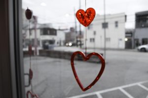 Valentine's Day decorations hang on windows.