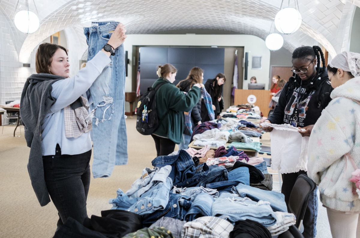 Students hold up clothes to get a better look at them. Clothes donated by students were made available for free by A La Mode at the Sustainable Fashion Fair. 