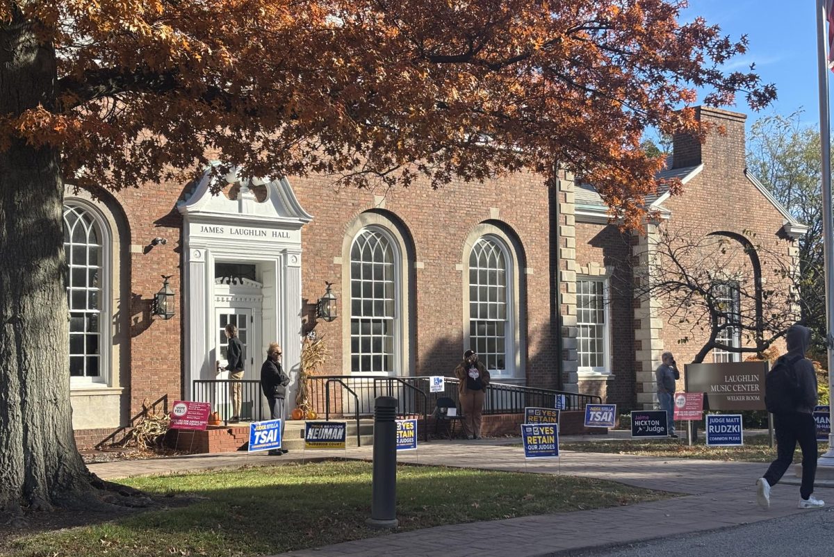 Poll workers stand outside Laughlin Music Center, an on-campus polling place. 