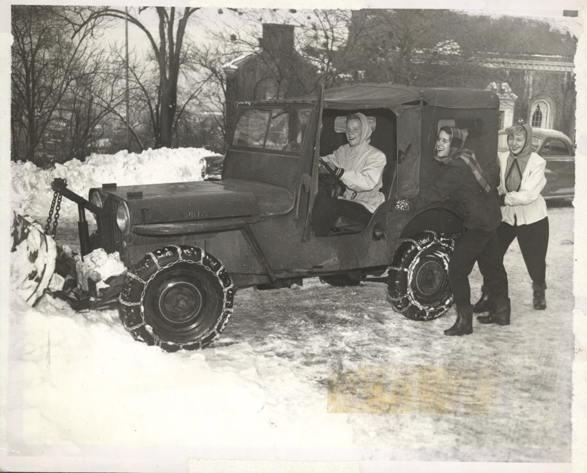 Gretchen Greer Donaldson '53 drives a Jeep through snow with the help of two other students in front of the Laughlin Music Center, 1952-1953. Photo courtesy of the Jennie King Mellon (JKM) library archives. 