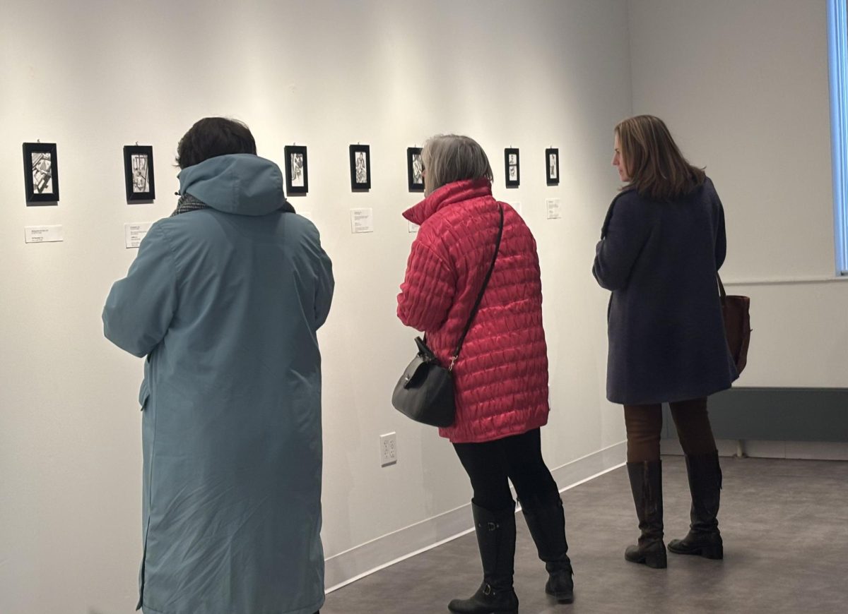 Guests peruse Natalie Callahan '23's Weavers of Benare exhibit during the opening reception on Jan. 15, 2026.
