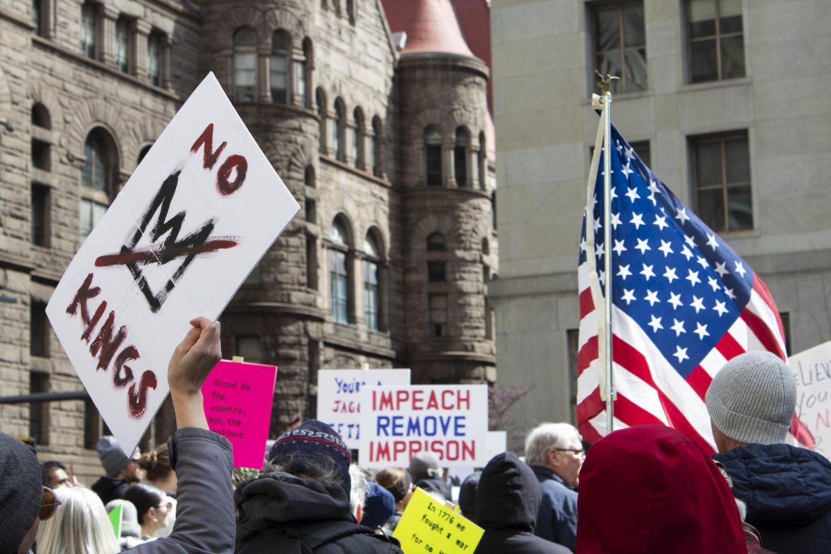 Protester holds “No Kings” sign during the March 28 rally Downtown at noon. 